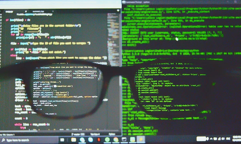 Python code on a monitor, seen through a pair of glasses